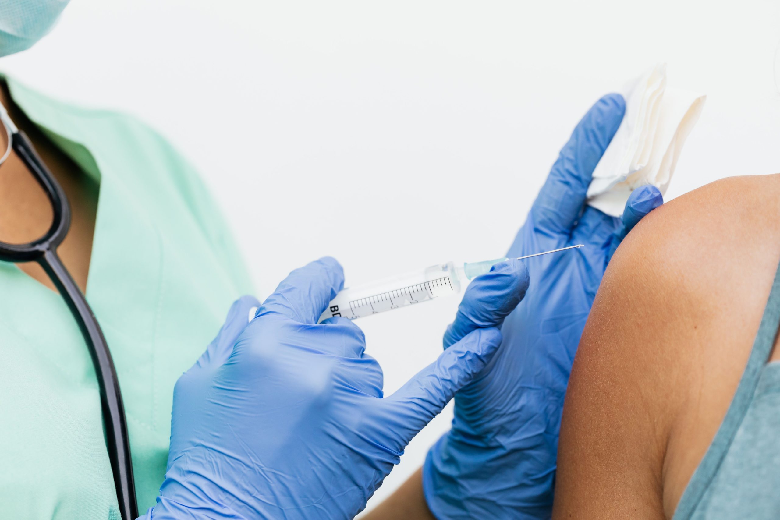 Nurse in gloves giving a vaccination to a patient in a healthcare setting